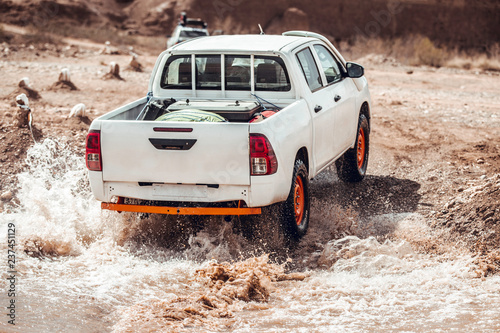 Fotografie White car pick-up crossing river