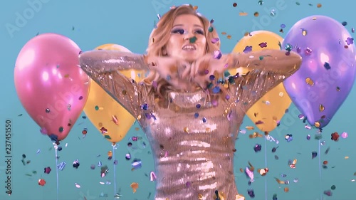 Confitti and crackers explode over the blonde. She is celebrating her birthday fun.