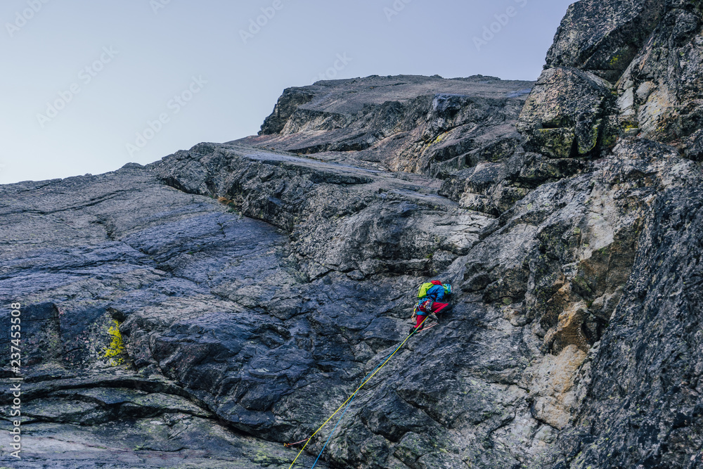 Alpine climbing adventure. A climber or an alpinist ascending big wall in High Tatras, Slovakia. Climbing on granit, Kezmarsky stit. A big wall climber in rock wall. Multipitch climbing, extreme sport