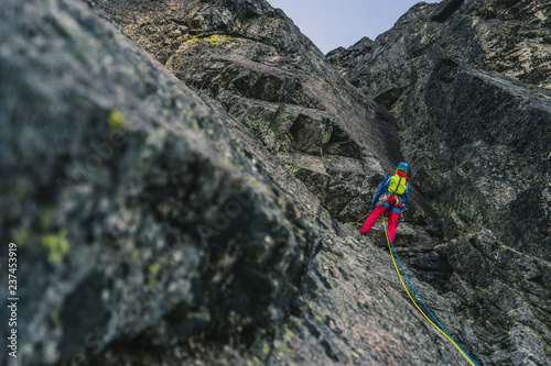 Alpine climbing adventure. A climber or an alpinist ascending big wall in High Tatras, Slovakia. Climbing on granit, Kezmarsky stit. A big wall climber in rock wall. Multipitch climbing, extreme sport