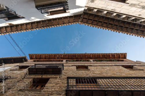 Wooden eaves of houses nearby in an old village of Spain, carved wood carving low angle shooting blue sky and clouds views, traditional architecture building