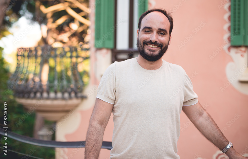 Man with a beard smiling in park Man with a beard smiling in park