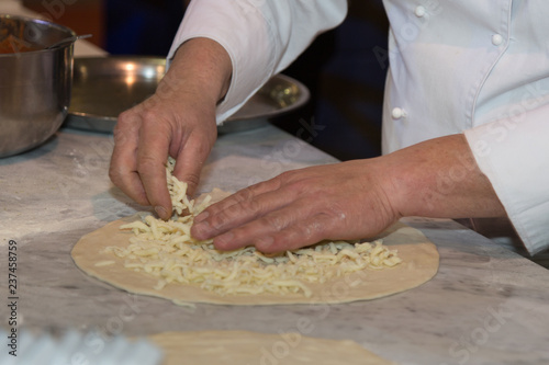 Pizza Maker who Prepares a Delicious Pizza with Cheese and Oregano