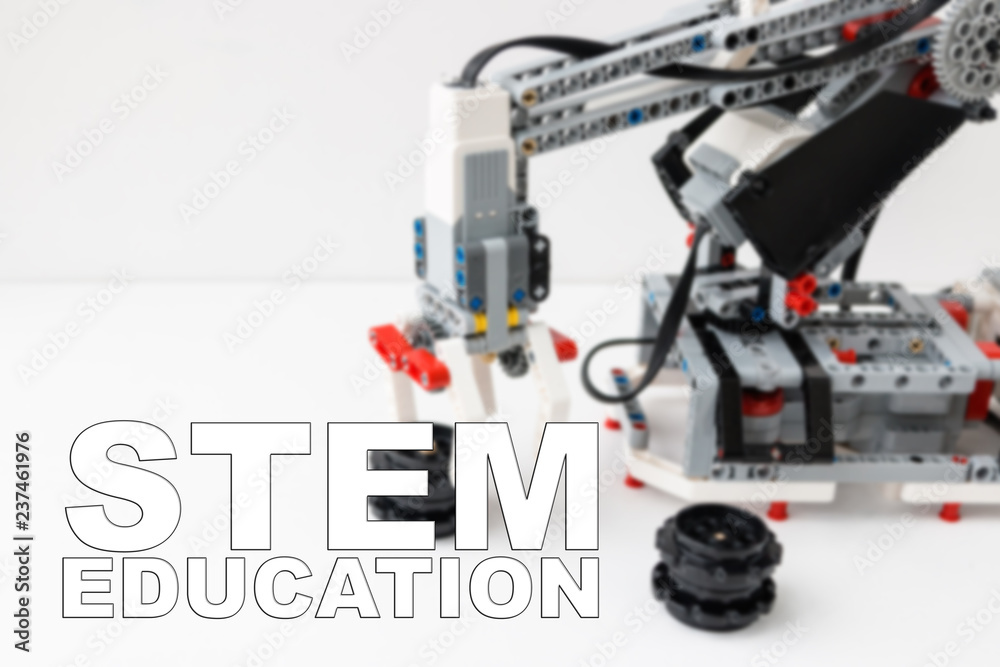 Concept of STEM education. Robot hand is on the background. Inscription 