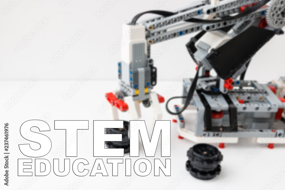 Concept of STEM education. Robot hand is on the background. Inscription Concept of STEM education. Robot hand is on the background. Inscription