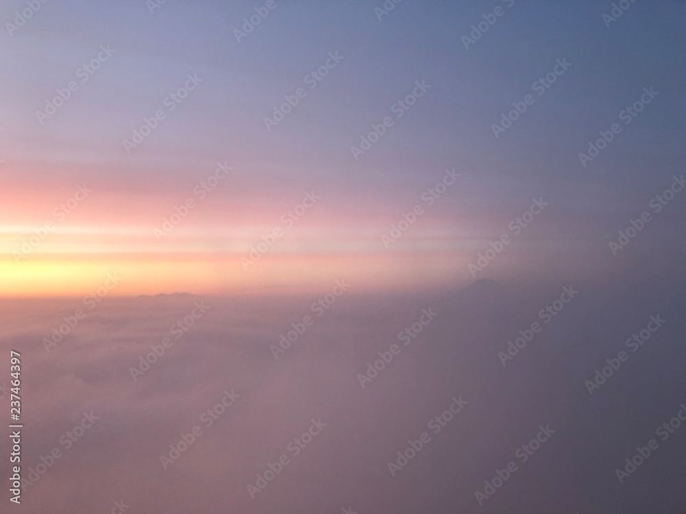 Fototapeta abstract pink blue and yellow sky at sunrise above the clouds