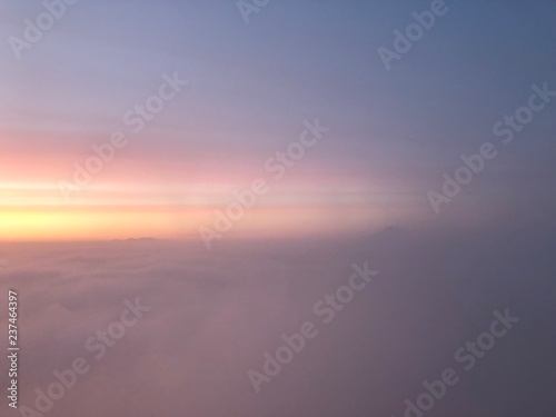 abstract pink blue and yellow sky at sunrise above the clouds