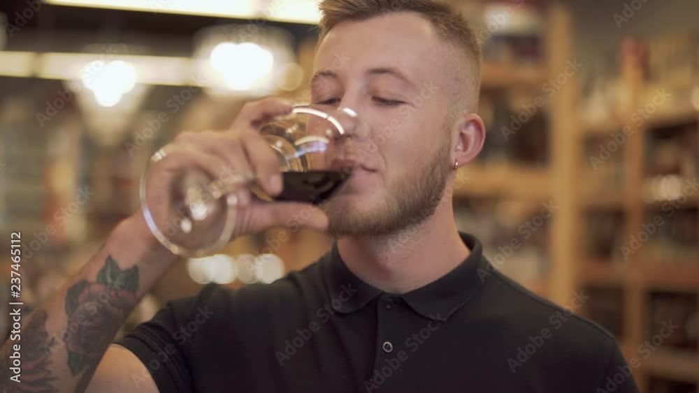 Portrait of a handsome man sniffing a wine glass. Smiling guy enjoys a sip of good wine. Portrait of a handsome man sniffing a wine glass. Smiling guy enjoys a sip of good wine.
