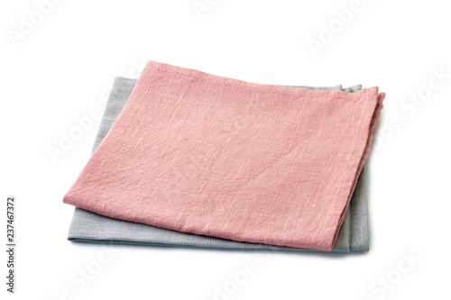 Folded pale pink and pale gray napkins stacked on white