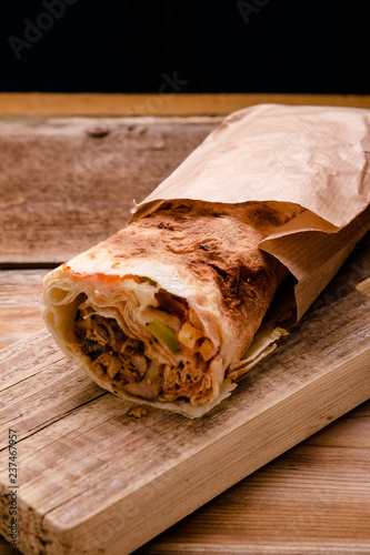 Doner Kebab Gyros Shawarma beef roll in pitta bread Wrap sandwich on wooden background. Copy space