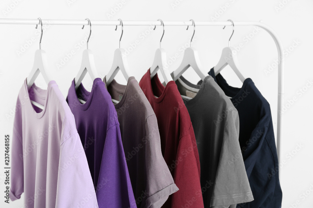 Obraz premium Men's clothes hanging on wardrobe rack against white background