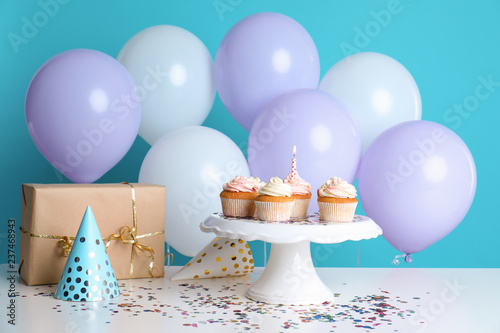Composition with birthday cupcakes and balloons on table
