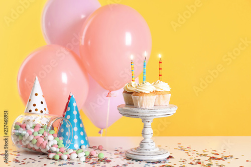 Composition with birthday cupcakes and balloons on table