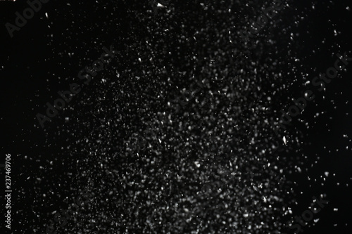 Snow flakes falling on black background. Winter weather