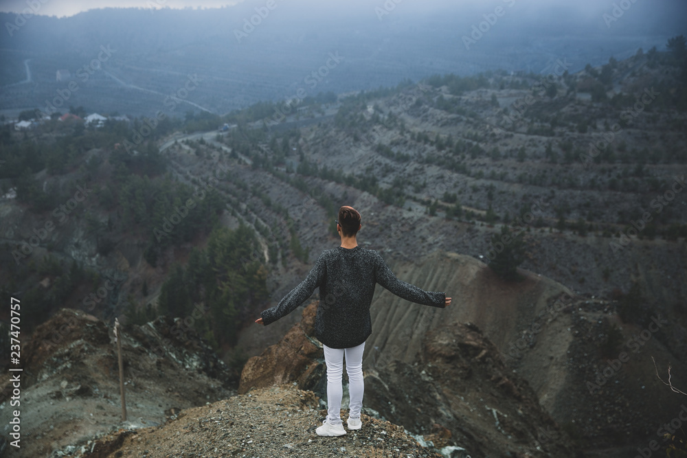 Obraz premium A young guy on the edge in the mountains