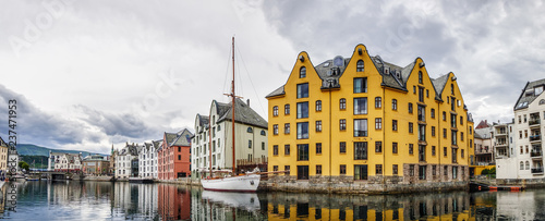 Yachts and boats at the waterfront of Alesund town, old architecture of Alesund city centre on the background, Norway photo