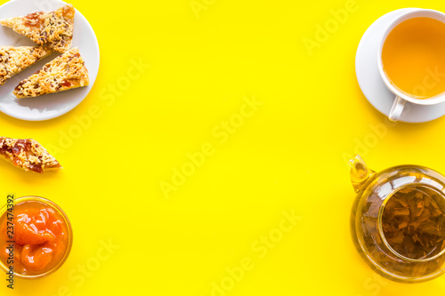 Dessert for evening tea. Cup of tea, fresh homemade cookies on yellow background top view copy space