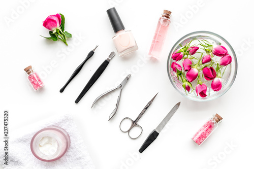 tools for manicure with spa salt and rose on white background top view
