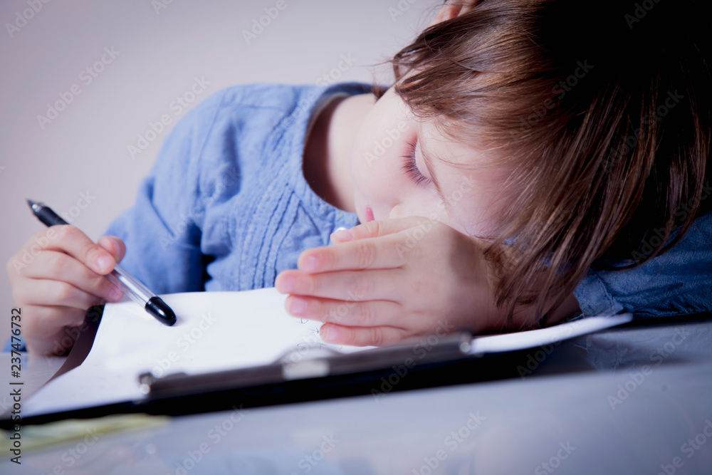 I want to sleep. Humorous photo of little cute business child girl tired from office work with documents.