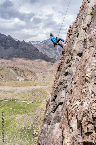 One person abseiling in the amazing mountain walls of Cajon del Arenas (Arenas Valley) on a steep wall called "Pared de Jabbah" (Jabbah Wall), amazing rock climbing activities inside Andes mountains
