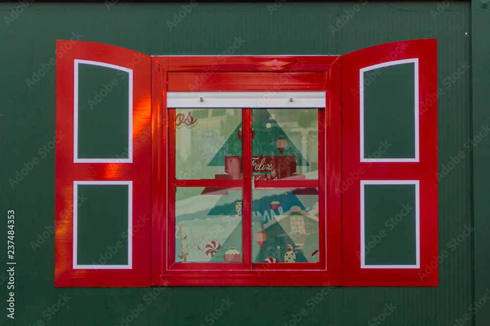 Red window on green background. Christmas house