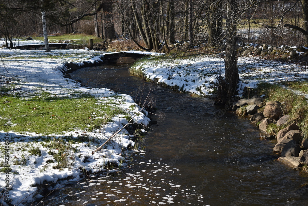 Winding river creek in a rural area in early winter light snow Winding river creek in a rural area in early winter light snow