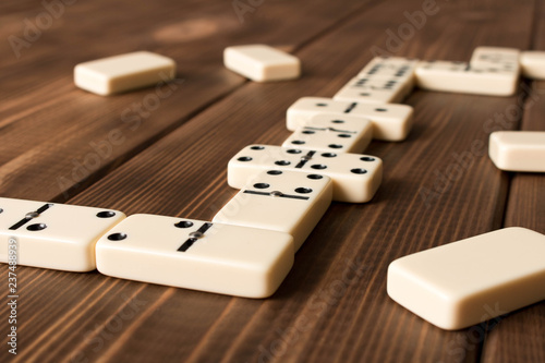 Playing dominoes on a wooden table. Domino effect