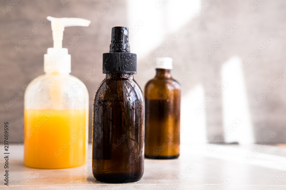 Spa cosmetics in bottles on gray concrete table. Copy space for text. Beauty blogging, salon therapy, branding mockup, minimalism concept