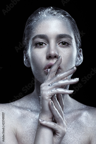 Beauty portrait of young gorgeous woman. Female with hand near face  on black background