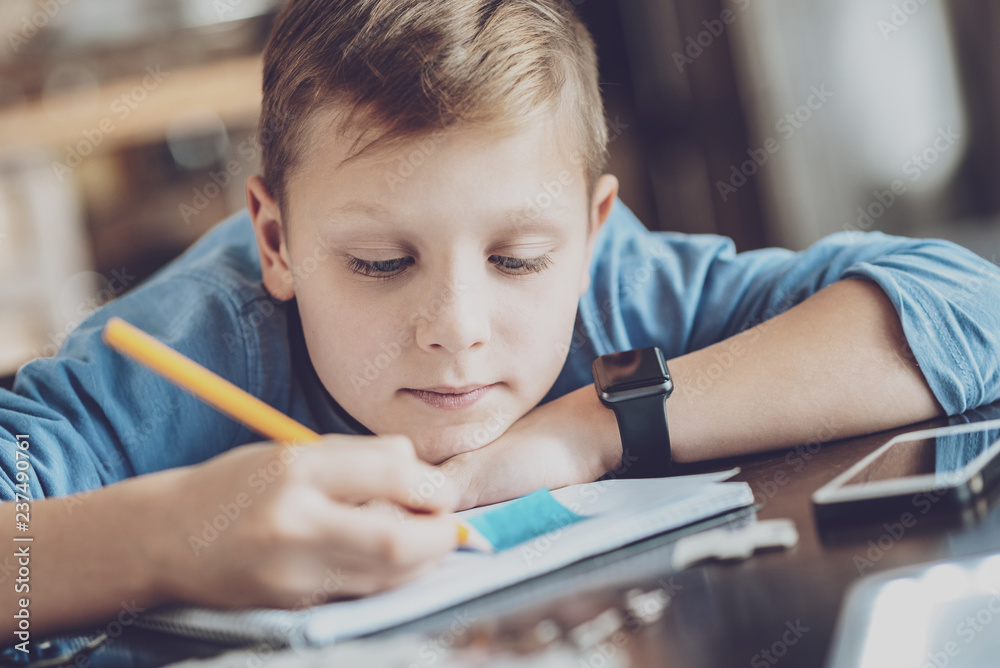 Thoughtful blonde kid writing task Thoughtful blonde kid writing task