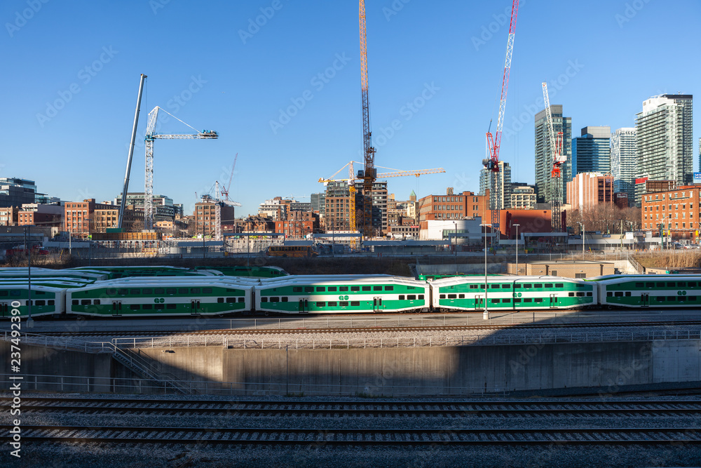 Toronto, Canada – December 4th 2018 view of the railroad tracks with a group GO green wagon trains to the entrance of the business center of Toronto Toronto, Canada – December 4th 2018 view of the railroad tracks with a group GO green wagon trains to the entrance of the business center of Toronto