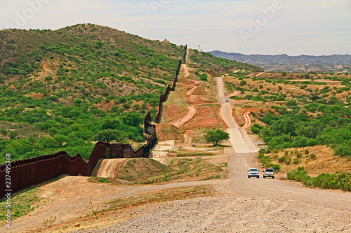 Obraz na plátne Border Fence beside a road near Nogales, Arizona separating the United States from Mexico with border patrol vehicle