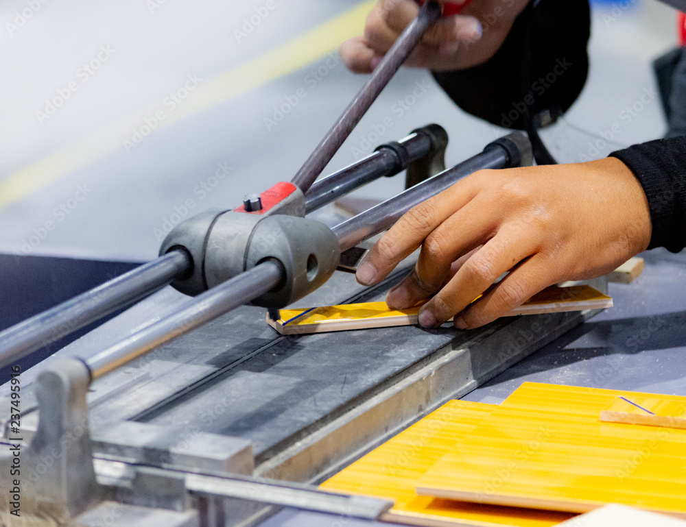 Cutting the floor tiles using a tile cutter machine, cutting ceramic