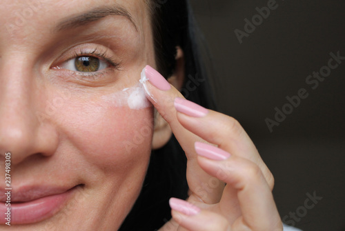 girl applies eye wrinkle cream