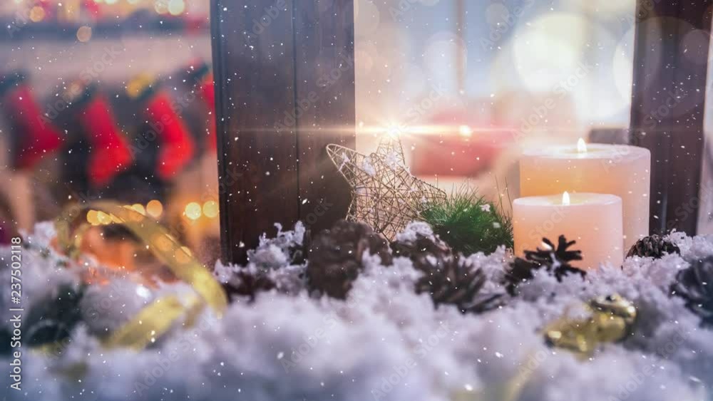 Candles and christmas decoration outside a window combined with falling snow