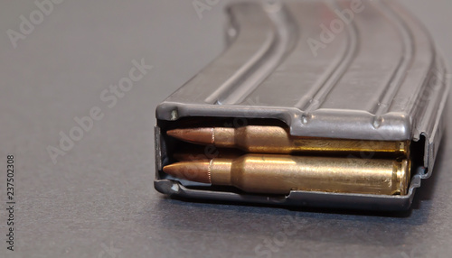 A rifle magazine loaded with .223 bullets on a gray background