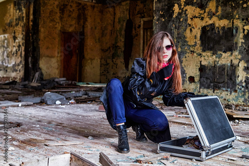 Girl in a black cloak with a diplomat in a ruined room. A spy in a secret meeting. Unusual photo shoot photo