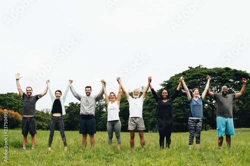 Happy diverse people holding hands in the park