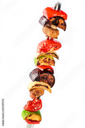 Grilled vegetable kebabs on skewers with cherry tomato, pepper, mushrooms, squash and onion on white background