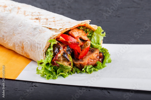 Vegetarian Burrito wraps from grilled vegetables and lettuce on dark wooden background. Healthy lunch