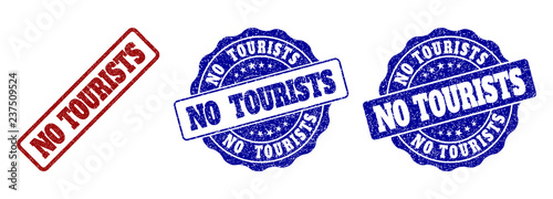 NO TOURISTS scratched stamp seals in red and blue colors. Vector NO TOURISTS labels with scratced style. Graphic elements are rounded rectangles, rosettes, circles and text labels.