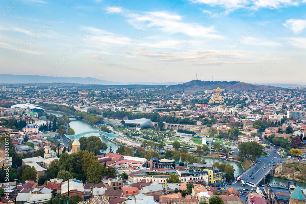 Tbilisi cityscape from a view point on a clear day showing old and modern architecture with mountains in the background, Georgia