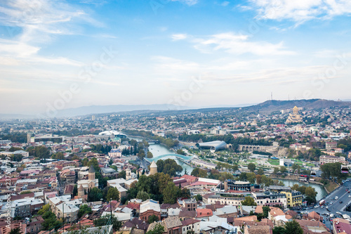 Fototapeta Naklejka Na Ścianę i Meble -  Tbilisi cityscape from a view point on a clear day showing old and modern architecture with mountains in the background, Georgia