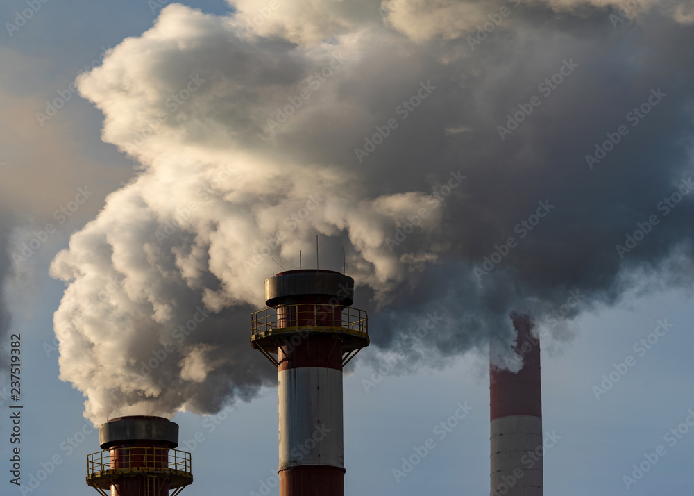 Smoking chimneys of a chemical plant emitting huge amounts of greenhouse gases.Air environment pollution concept.