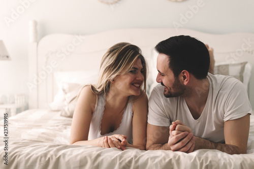 Young attractive couple having romantic time in bed