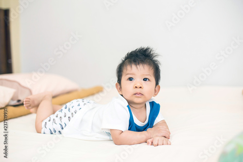 Portrait of a crawling baby on the bed in her room