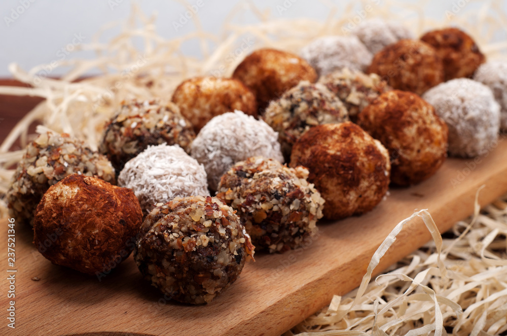 Hand-made sweets made from dried fruits, nuts and seeds (without sugar). Macro shooting. Shallow depth of field, blurred background. Delicious and healthy fitness candy Hand-made sweets made from dried fruits, nuts and seeds (without sugar). Macro shooting. Shallow depth of field, blurred background. Delicious and healthy fitness candy