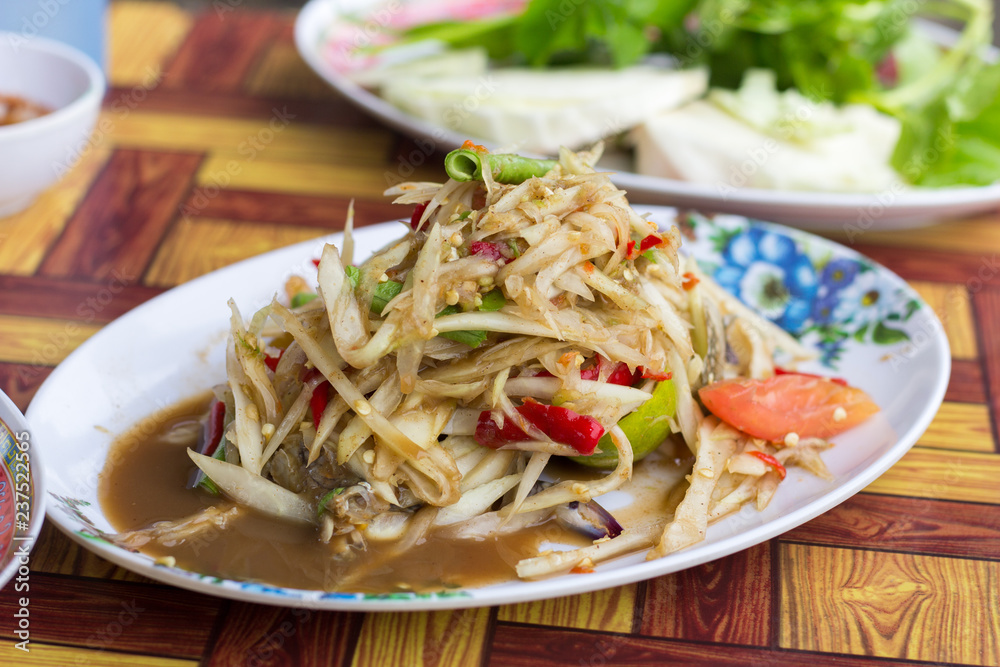 SOM-TAM, Thai delicious raw papaya salad with unique taste hot and spicy, this dish with tomato and crab. Papaya salad with red chili.