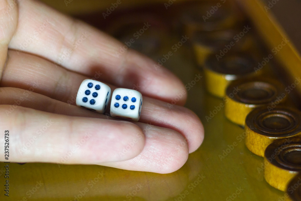 male hand holds dice in the game of backgammon male hand holds dice in the game of backgammon