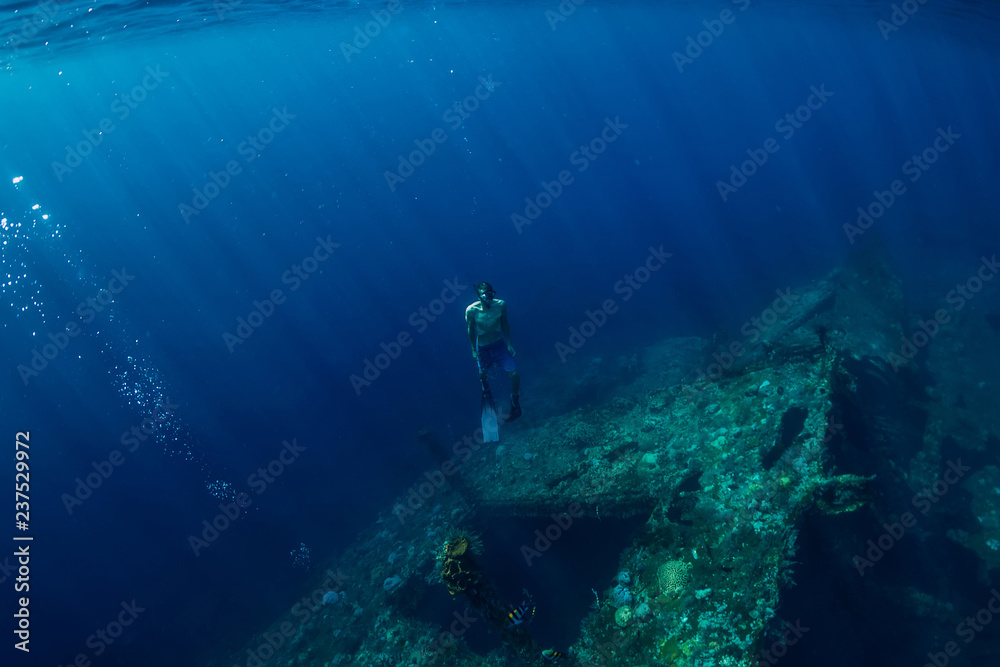 Free diver man dive underwater at shipwreck in Bali Free diver man dive underwater at shipwreck in Bali